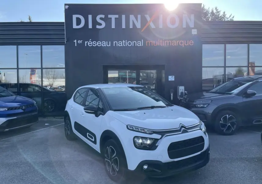 Citroën C3 blanc banquise vue 3/4 avant droit avec protections latérales noires et jantes 3D 16 pouces.