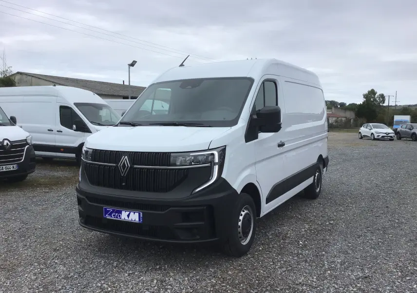 Renault Master blanc en 3/4 avant droit sur parking, avec calandre noire et pare-chocs contrasté visible