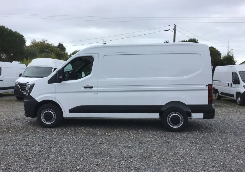 Vue latérale droite d'un utilitaire Renault Master blanc L2H2 2025 avec protections noires sur un parking.