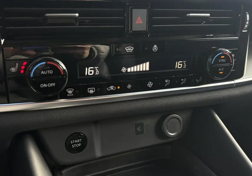 Vue rapprochée de la console centrale du Nissan Qashqai III noir, affichant la climatisation automatique bi-zone à 16°C.