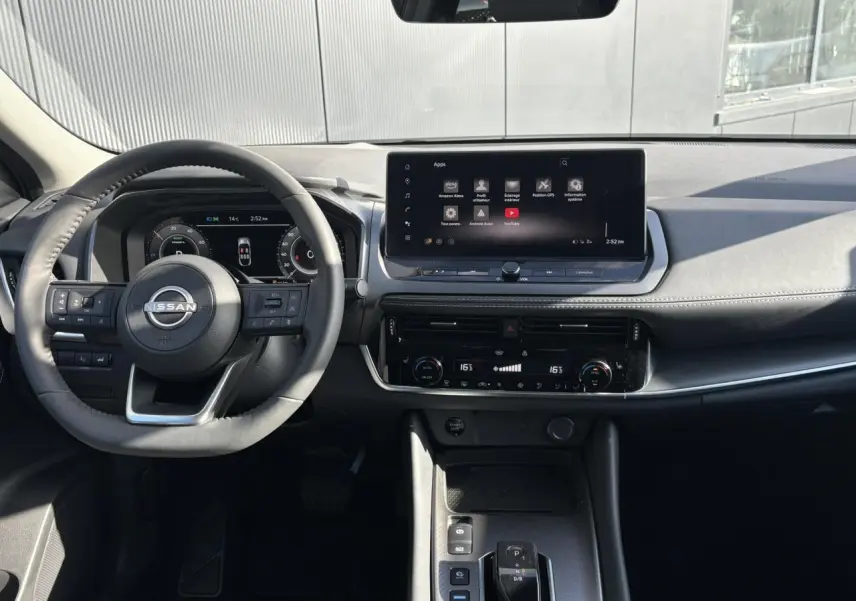 Vue intérieure du tableau de bord et volant noir du Nissan Qashqai III e-Power avec écran tactile central et commandes au volant.