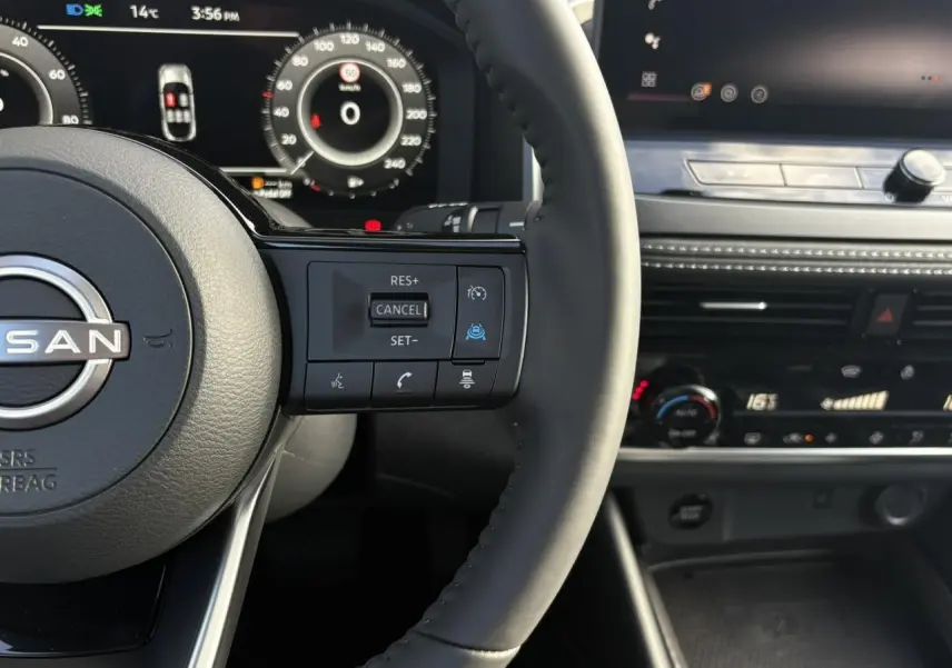 Vue rapprochée du volant noir du Nissan Qashqai 2025 avec commandes au volant et tableau de bord numérique.