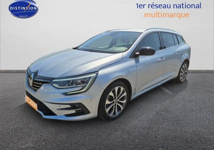 Renault Mégane Break gris titanium vue 3/4 avant droit avec jantes alliage et feux LED allumés.