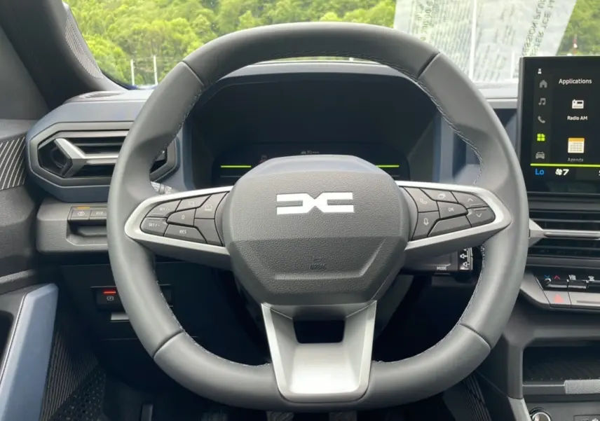 Vue rapprochée du volant multifonction du Dacia Bigster 2025, avec tableau de bord numérique et écran tactile.