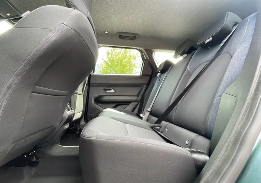 Vue intérieure arrière du Dacia Bigster 2025 vert cèdre, montrant les sièges arrière en tissu noir avec ceinture de sécurité.