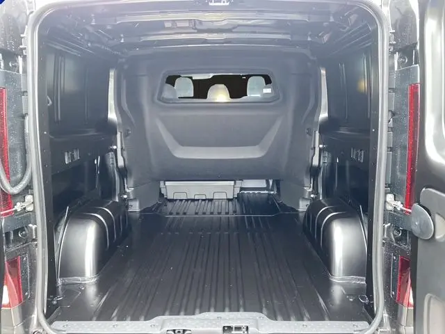 Vue intérieure arrière du Renault Trafic cabine approfondie noir 2025, montrant l'espace de chargement vide avec cloison vitrée.