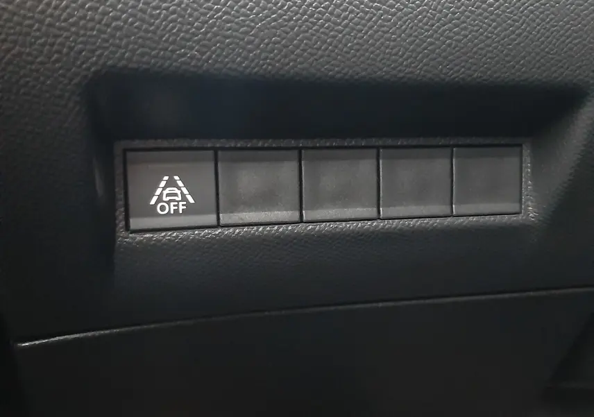 Bouton de désactivation de l'aide au maintien de voie sur tableau de bord noir du Peugeot 2008 blanc nacré 2023.