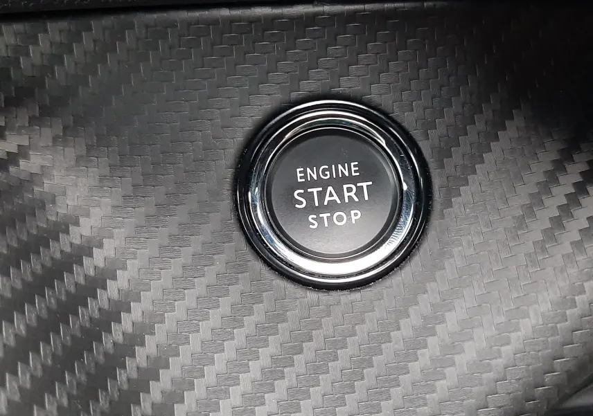 Bouton start/stop moteur sur tableau de bord en carbone du Peugeot 2008 GT blanc nacré toit noir.