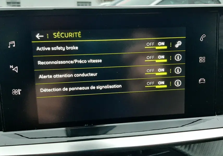 Écran tactile intérieur du Peugeot 2008 2023 affichant les options de sécurité activées dans un environnement lumineux extérieur.