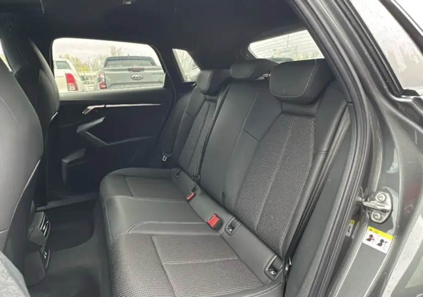 Vue côté droit de l'habitacle arrière de l'Audi A3 2025 gris Daytona avec sellerie cuir tissu et appuie-têtes intégrés.