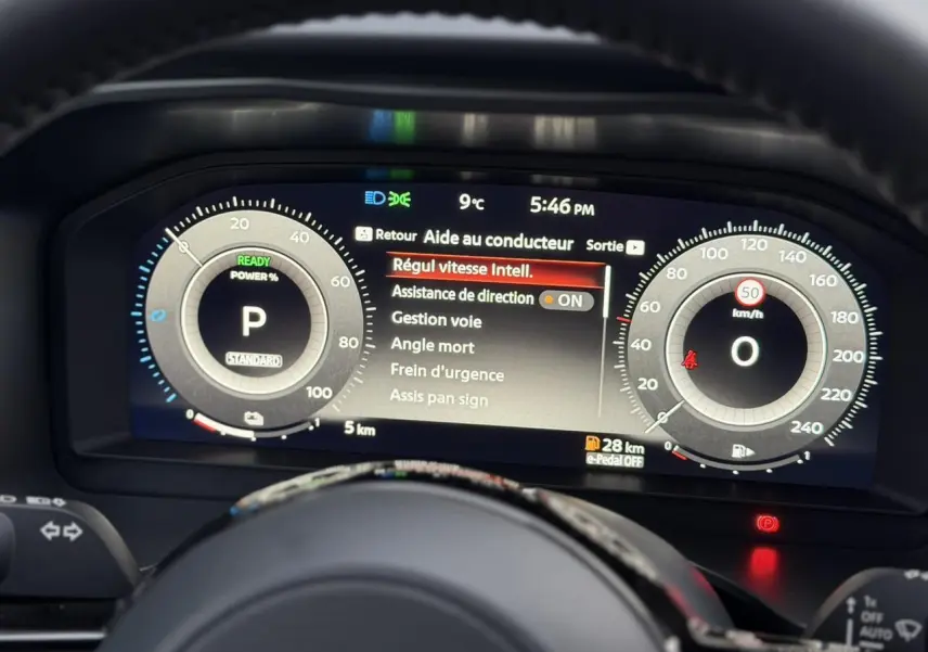 Tableau de bord numérique du Nissan Qashqai gris Squale, vue frontale centrée sur l'affichage des aides à la conduite.