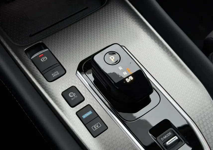 Gros plan sur la console centrale du Nissan Qashqai gris, montrant le sélecteur de boîte auto et les boutons de commande.