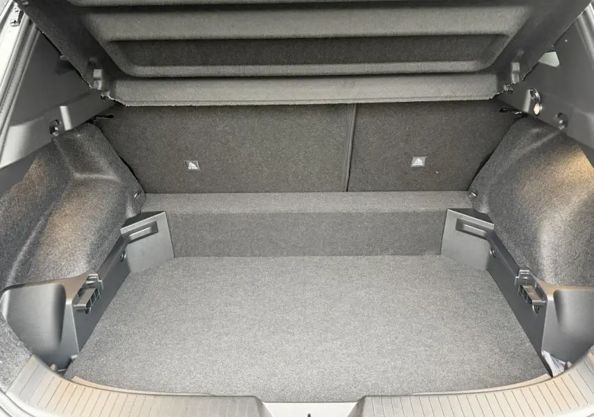 Coffre ouvert en vue arrière d'un Nissan Qashqai III e-Power gris Squale, montrant un espace de chargement vide et propre.