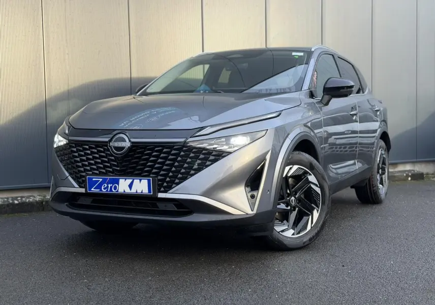Vue 3/4 avant droit du Nissan Qashqai III e-Power 2025 en gris Squale avec calandre noire et jantes alliage bicolores.