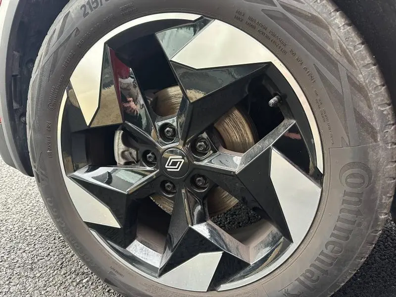 Gros plan sur la jante noire et argentée du Renault Captur 2025 Rouge Flamme/Noir Étoilé, avec logo central distinctif.