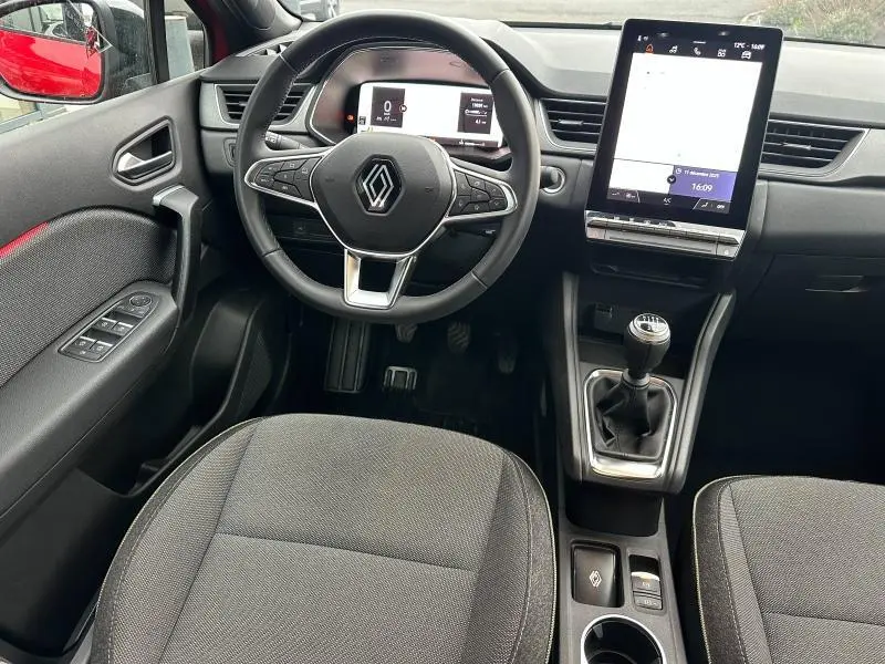 Vue intérieure avant du Renault Captur 2025 avec volant multifonction, écran tactile vertical et levier de vitesses manuel.