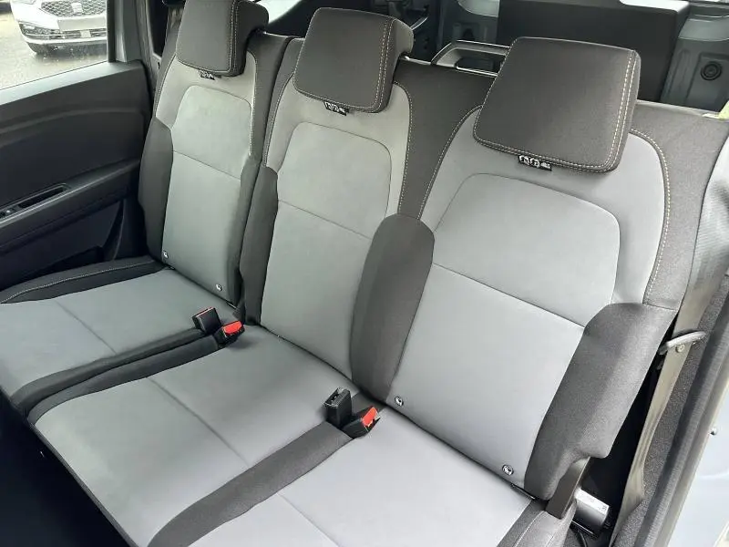 Vue intérieure sur la banquette arrière grise et noire du Dacia Jogger 1.6 hybrid 2025, avec appuie-têtes et ceintures visibles.