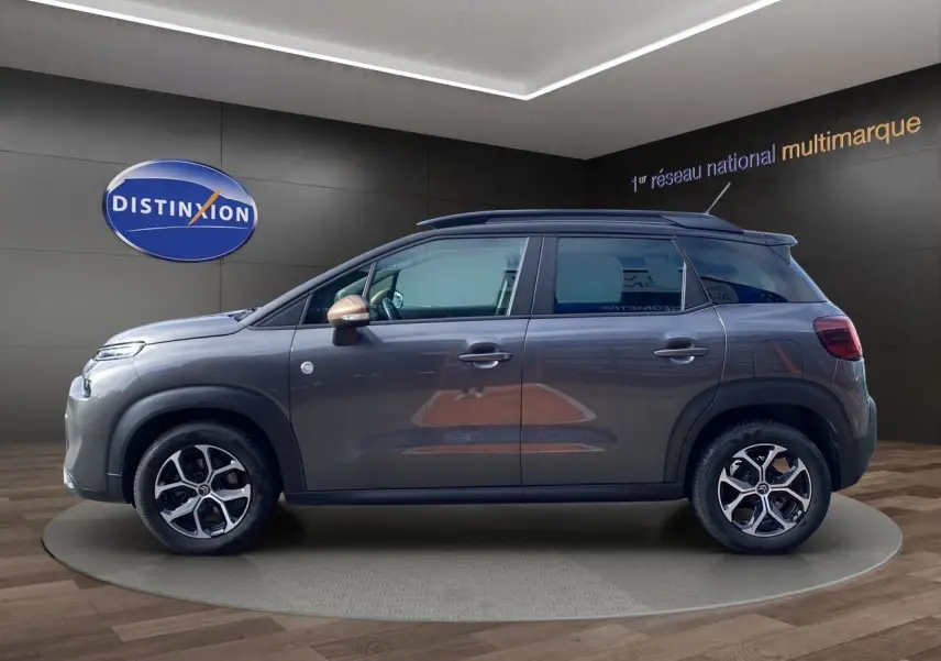 Vue de profil côté gauche d'une Citroën C3 Aircross gris platinium avec rétroviseurs couleur cuivre et jantes alliage.