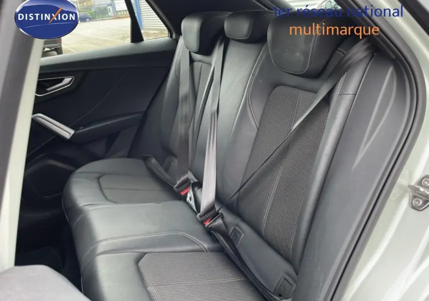 Vue intérieure sur la banquette arrière en cuir noir de l'Audi Q2 35 2.0 TDI S-Line, porte arrière ouverte.