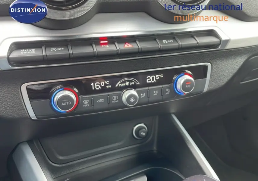 Vue rapprochée de la console centrale de l'Audi Q2 35 2.0 TDI S-Line 2025, mettant en valeur la climatisation digitale et les commandes.