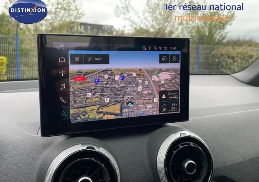 Vue intérieure centrée sur l’écran tactile du système de navigation d’un Audi Q2 2025 argent rose métal.