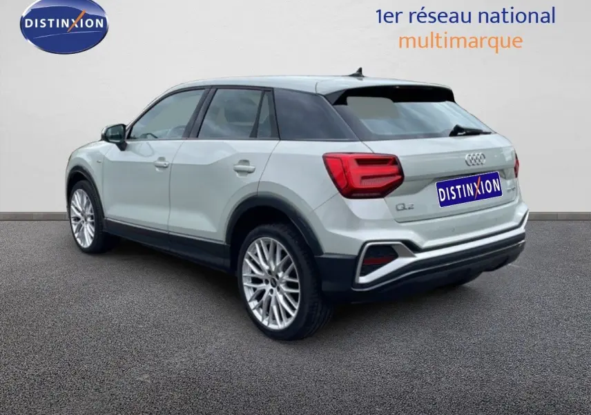Audi Q2 argent rose métal vue 3/4 arrière droit, jantes alliage 19 pouces et feux arrière LED distinctifs.
