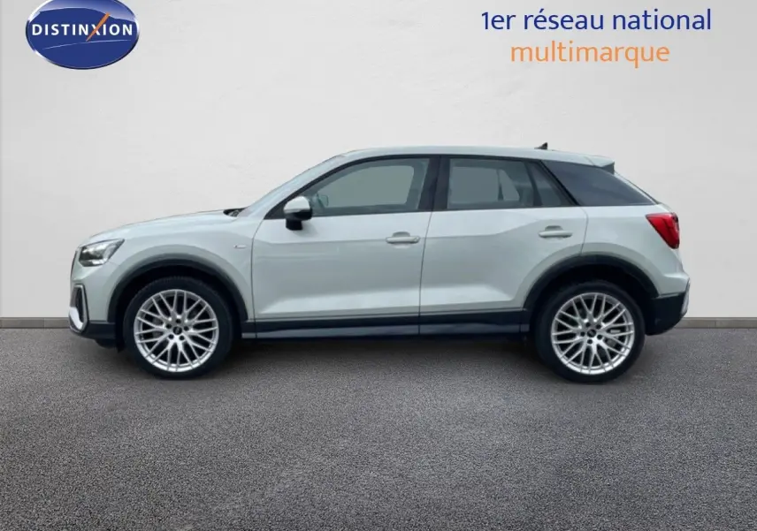 Vue de profil côté gauche d'un Audi Q2 35 2.0 TDI S-Line argent rose métal avec jantes alliage 19 pouces.