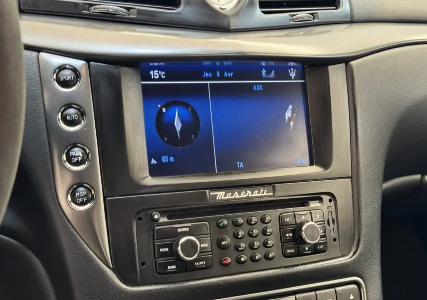 Gros plan sur la console centrale de la Maserati Granturismo S 4.7 2010, écran navigation et commandes noires.