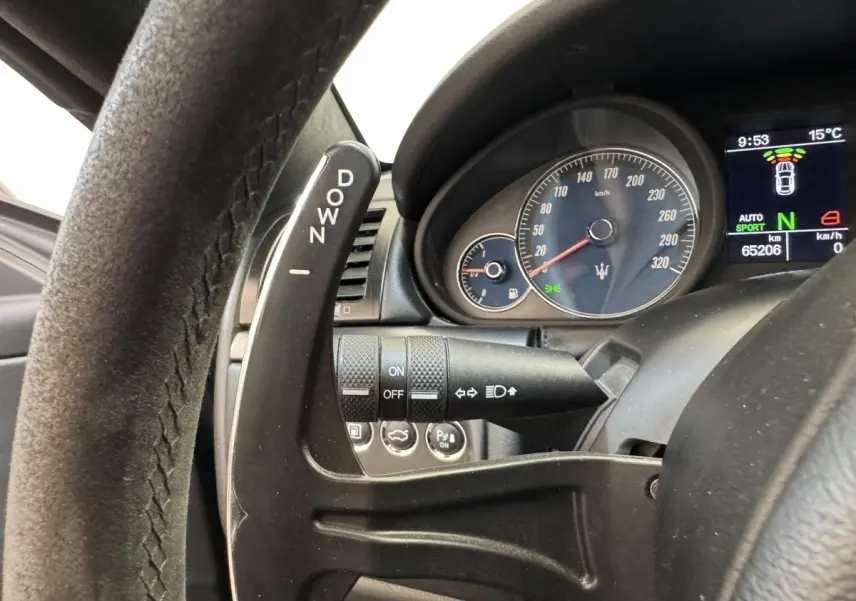 Gros plan sur le levier de changement de vitesse au volant et le compteur gris foncé d'une Maserati Granturismo S 4.7 2010.