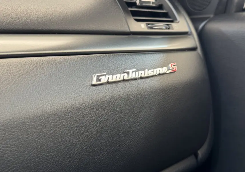Gros plan sur l’inscription GranTurismo S en chrome sur la planche de bord noire du Maserati Granturismo S 2010.