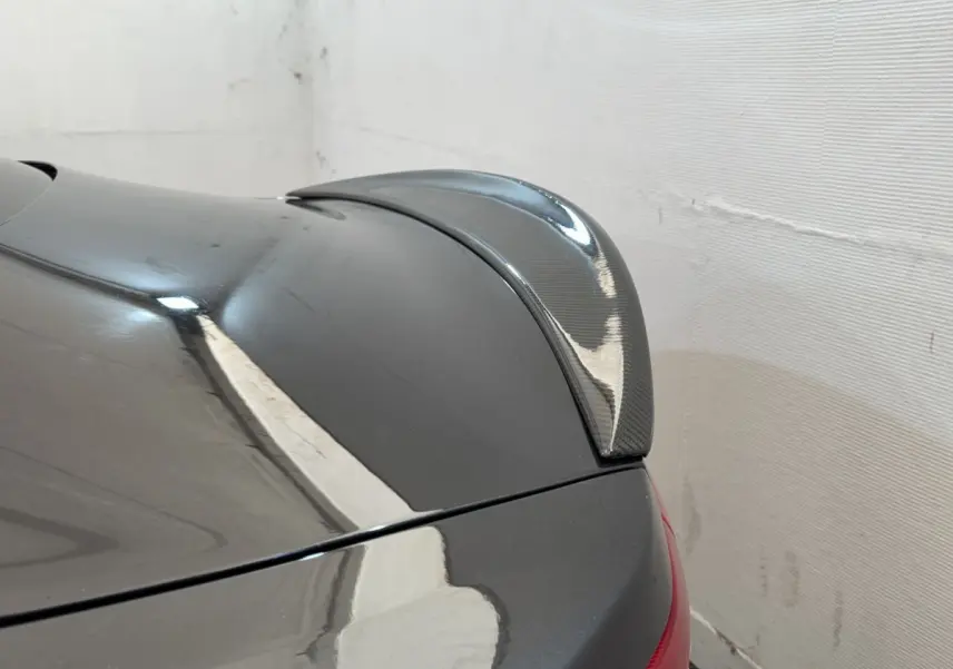 Détail du spoiler arrière en carbone sur une Maserati Granturismo S 4.7 gris foncé vue de trois quarts arrière droit.