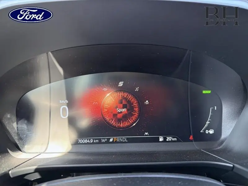 Vue rapprochée du tableau de bord numérique du Ford Kuga 2023, affichant le mode Sport et les informations de conduite.
