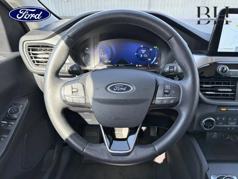 Vue frontale du volant cuir multifonction noir du Ford Kuga 2023 avec tableau de bord numérique et écran tactile GPS.