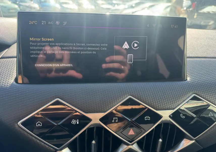 Vue rapprochée de la console centrale du DS3 2024, écran tactile avec commandes en losange et finition noire texturée.