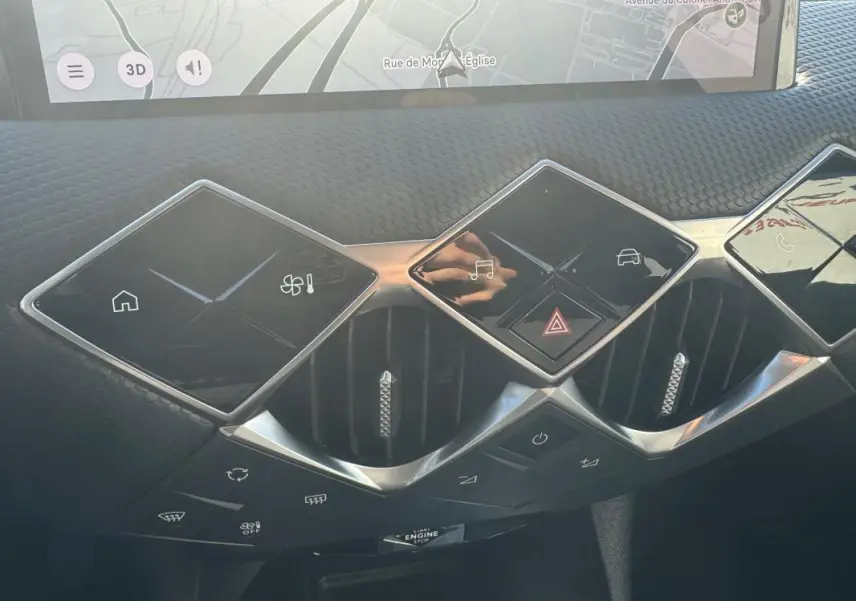 Vue rapprochée du tableau de bord de la DS3 2024 gris, montrant les commandes tactiles et les aérateurs au design géométrique.