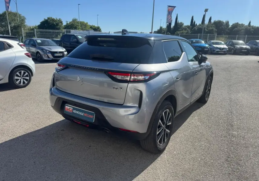 Vue 3/4 arrière droite d'une DS3 100 BVM6 Bastille gris métallisé avec jantes alliage 18 pouces sur parking extérieur.