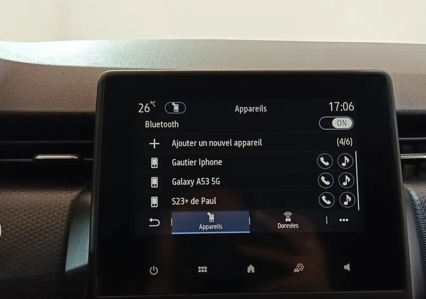 Écran tactile central de la Renault Clio Business E-TECH 140 blanc, affichant la connexion Bluetooth et les appareils appairés.