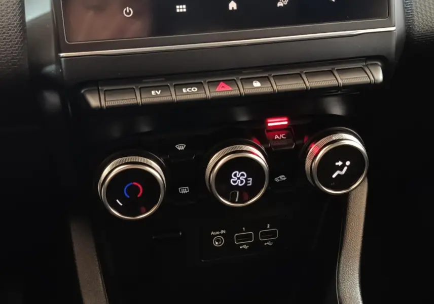 Vue rapprochée des commandes de climatisation et connectiques USB de la Renault Clio Business E-TECH blanche de 2021.