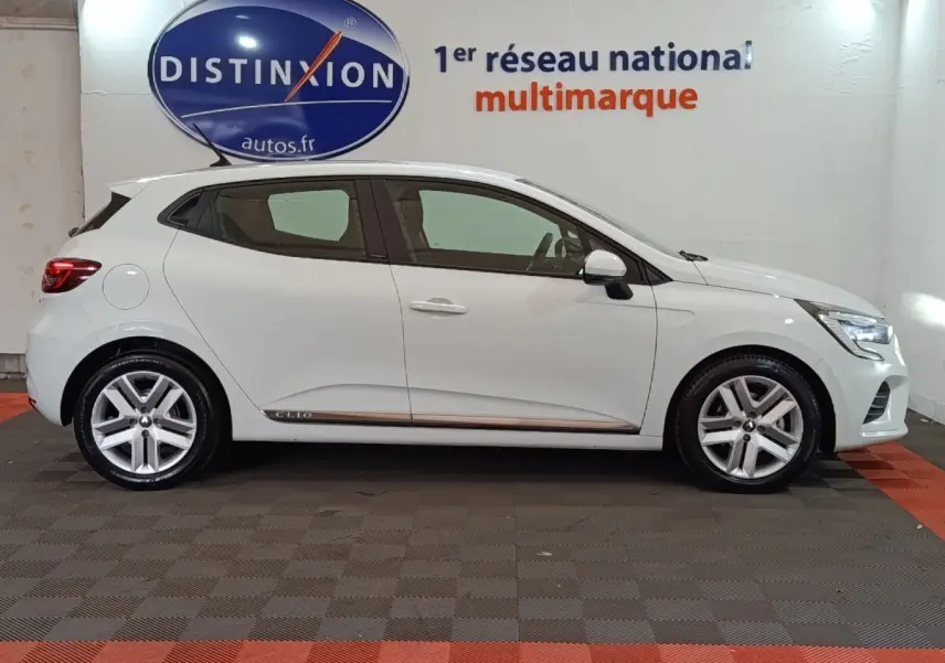 Profil droit de la Renault Clio Business E-TECH 140 blanche de 2021 avec jantes alliage et logo Clio sur la bas de caisse.