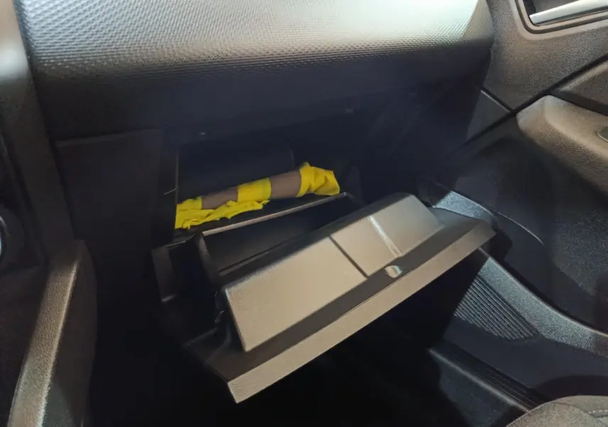 Gant de boîte à gants ouvert côté passager dans l'habitacle noir d'une Renault Clio Business E-TECH blanche 2021.