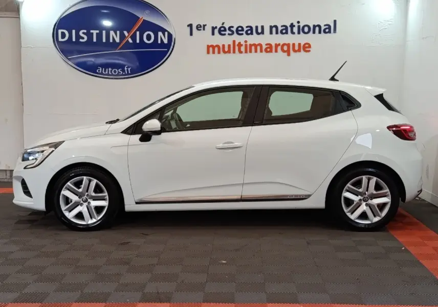 Profil droit d'une Renault Clio Business E-TECH 140 blanche, avec jantes alliage et logo Clio sur la bas de porte.