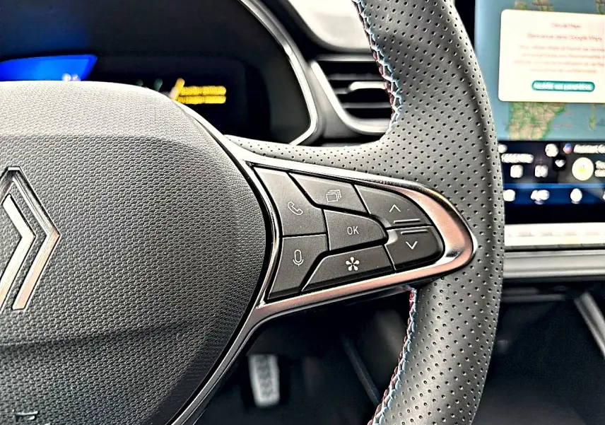 Gros plan sur le volant perforé avec commandes multifonctions et surpiqûres tricolores du Renault Symbioz 2026.
