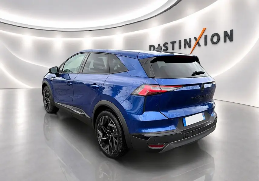 Vue 3/4 arrière du Renault Symbioz 2026 en bleu iron avec jantes noires et feux arrière LED distinctifs.