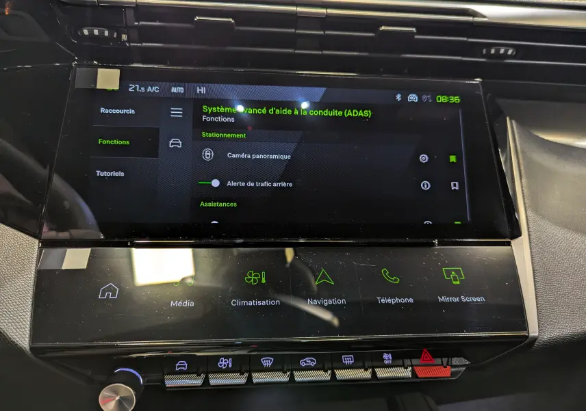 Vue rapprochée de l'écran tactile central et des commandes du tableau de bord du Peugeot 308 GT blanc Okénite 2024.
