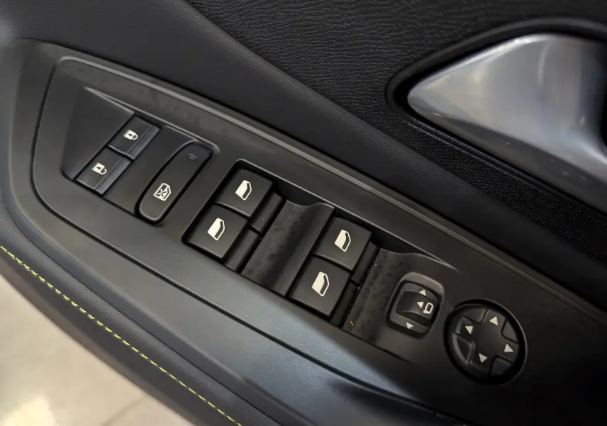 Gros plan sur les commandes de vitres et rétroviseurs côté gauche, garniture noire avec surpiqûres vertes, Peugeot 308 2024.