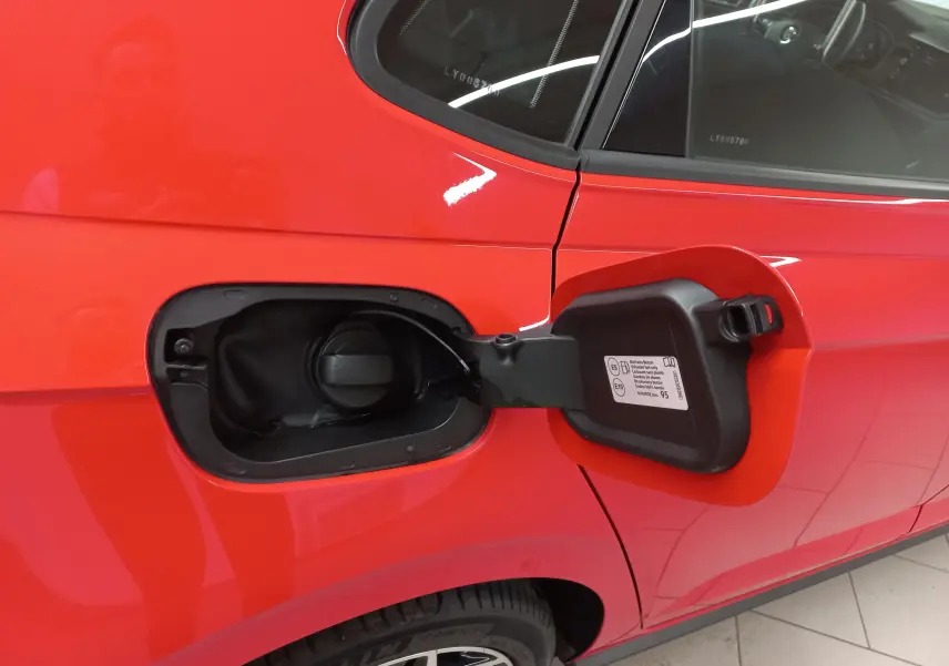 Gros plan sur la poignée de porte côté gauche d'une Volkswagen Polo Rouge Flash avec intérieur visible au travers de la vitre.