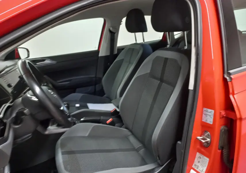 Vue intérieure côté conducteur de la Volkswagen Polo Rouge Flash 2019, sièges en tissu gris et tableau de bord visible.