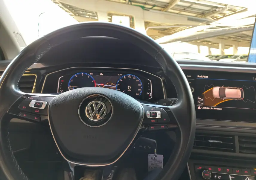 Vue intérieure centrée sur le volant Volkswagen Polo Rouge Flash 2019 avec affichage numérique et écran ParkPilot.