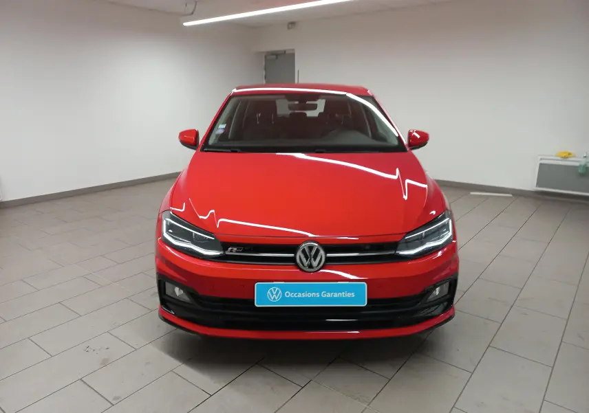 Vue frontale d'une Volkswagen Polo Rouge Flash finition R-Line avec phares LED et calandre noire brillante.