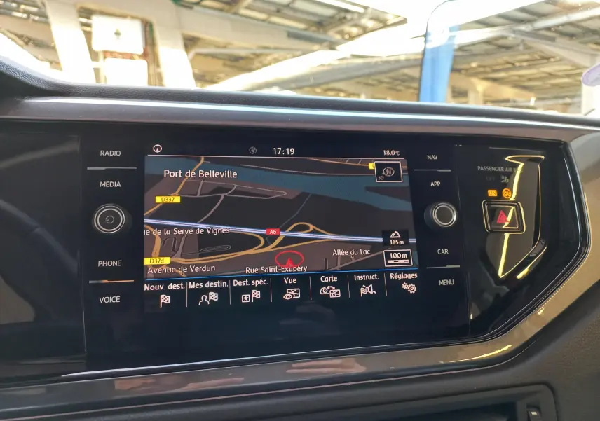 Vue rapprochée de l'écran tactile central du tableau de bord de la Volkswagen Polo Rouge Flash avec navigation affichée.